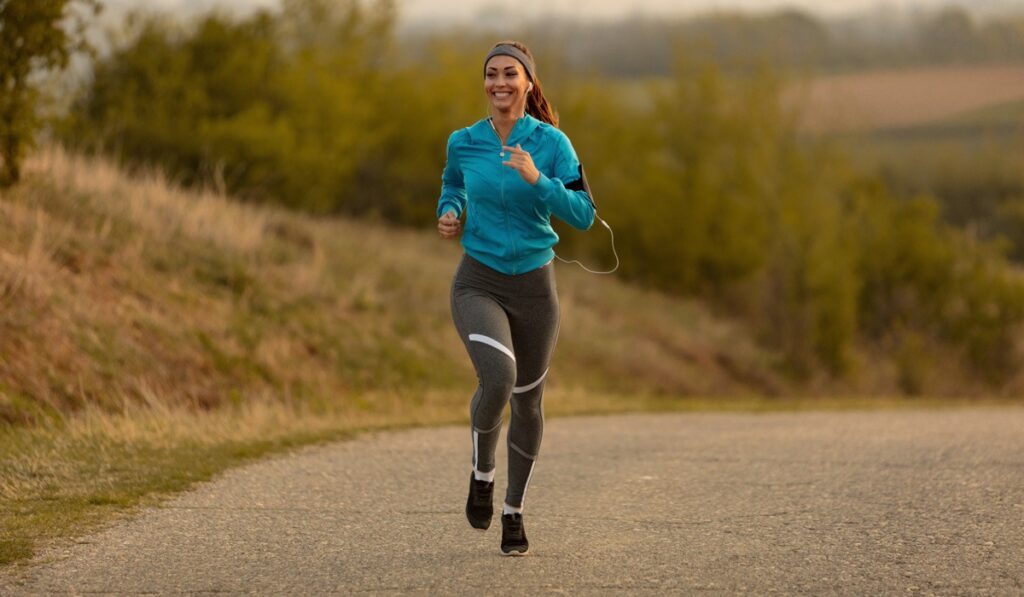 Smiling woman running on country road