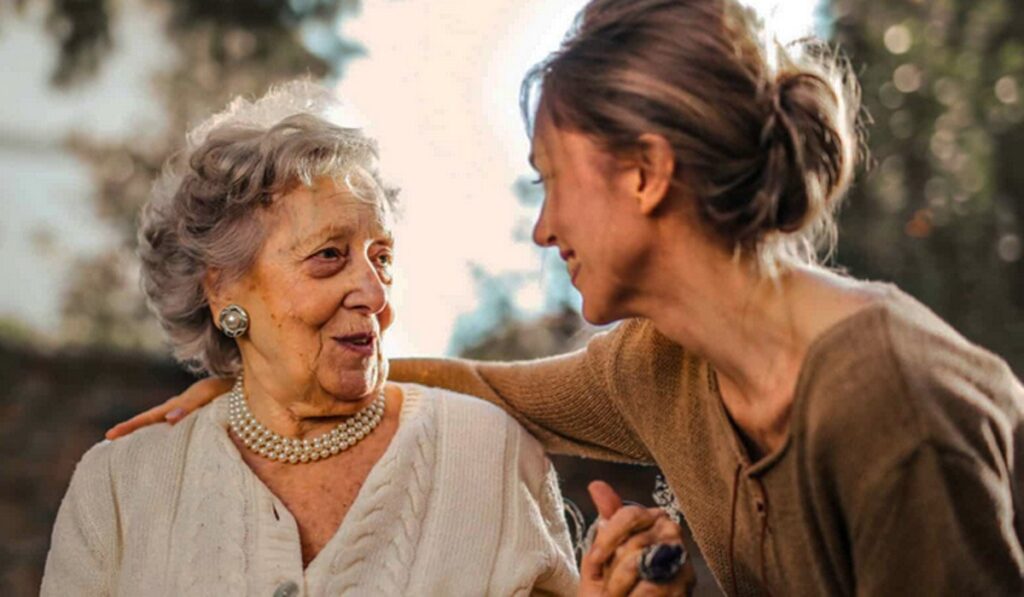 Senior and caregiver discussing fitness tracker