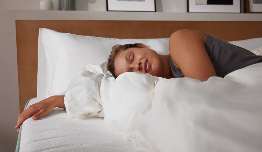 Woman sleeping peacefully on white sheets